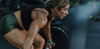 Stretching Barely Prevents Injuries. Strength Training Cuts Them by Two Thirds. A woman lifting a loaded barbell in a gym