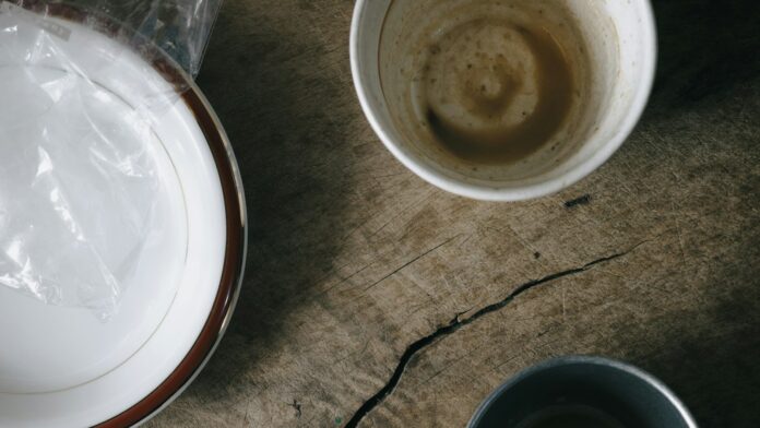 Used breakfast dishes and a crumpled napkin on a wooden table