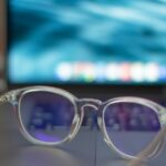 A pair of silver-framed eyeglasses resting on a white table