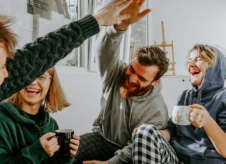 Four friends laughing together over coffee