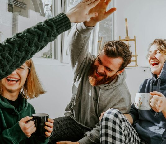 Two Researchers Disagreed About Money and Happiness. So They Ran the Study Together. Four friends laughing together over coffee