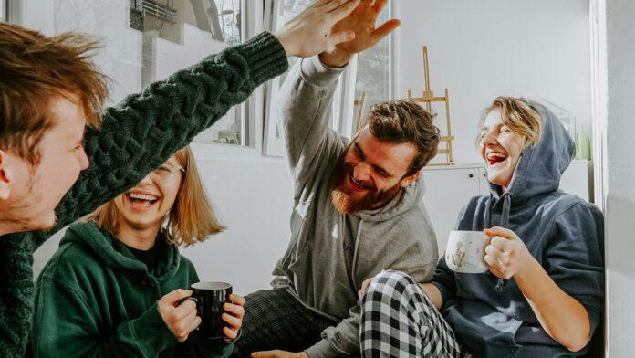 Four friends laughing together over coffee