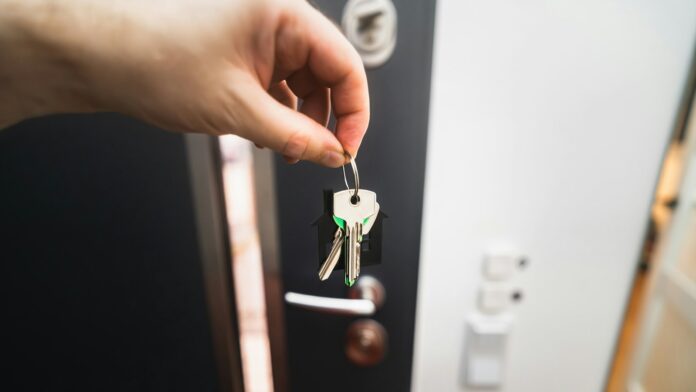 A person holding a key to a door