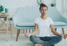 The Meditation Researchers Auditing Their Own Field A young woman sitting cross-legged meditating on the floor at home