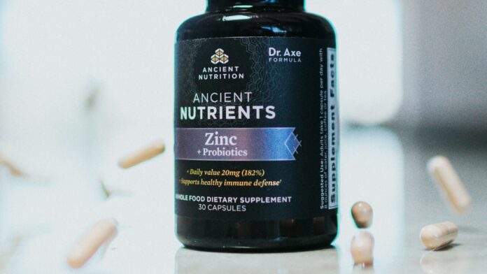 A bottle of vitamin supplements on a plain surface