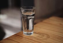 The eight-glasses rule is a sentence someone deleted A glass of water on a wooden surface