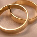 The 50% Divorce Rate Was True for About One Year. You Can Name It. Two interlocking gold wedding bands on a textured surface